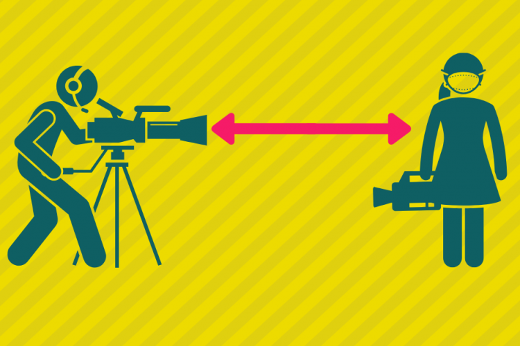 two people holding camera and standing 6 feet apart