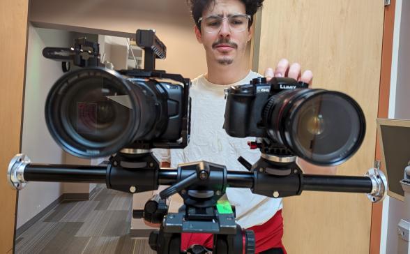 a person adjusts two cameras on a rail