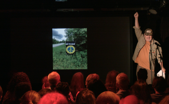 A man with his arm raised presenting a slide show of peace signs