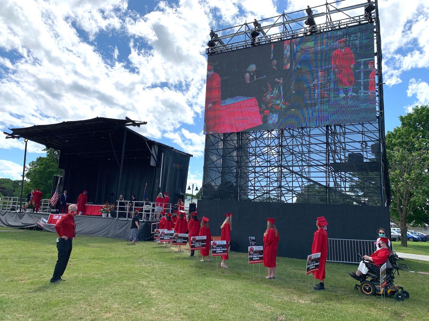 CVU grads line up for diplomas wearing red robes and mortarboards