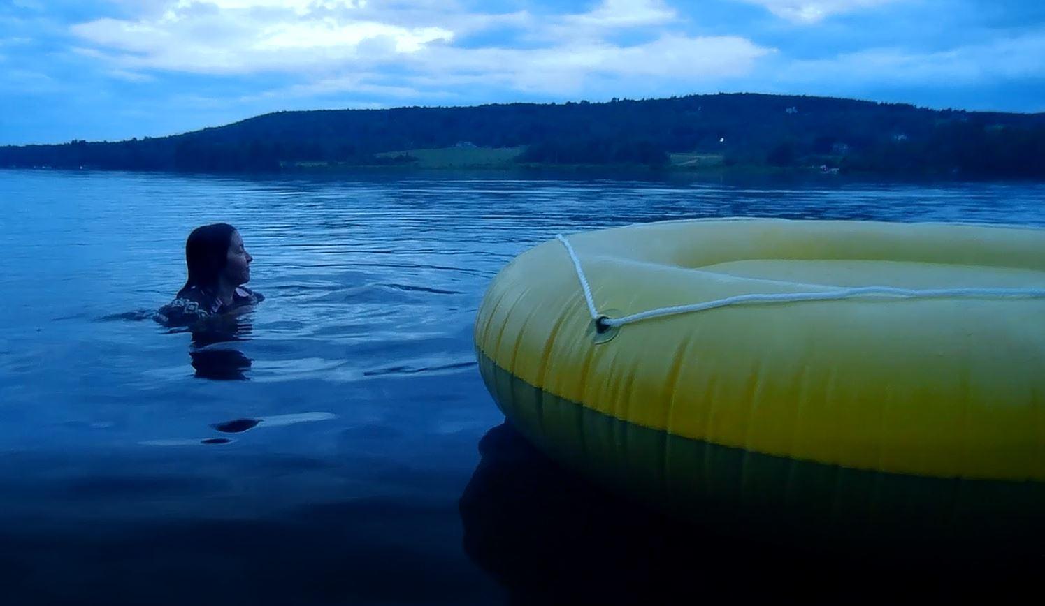 Woman in water by raft