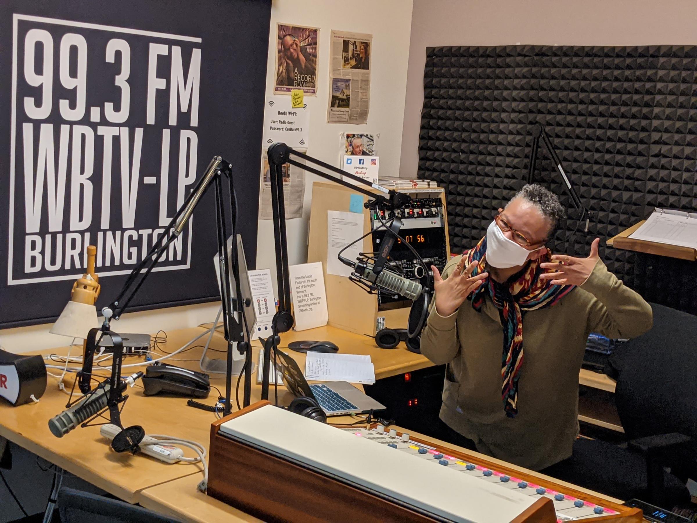 DJ Melo Grant wearing mask and gesturing with hands while in studio