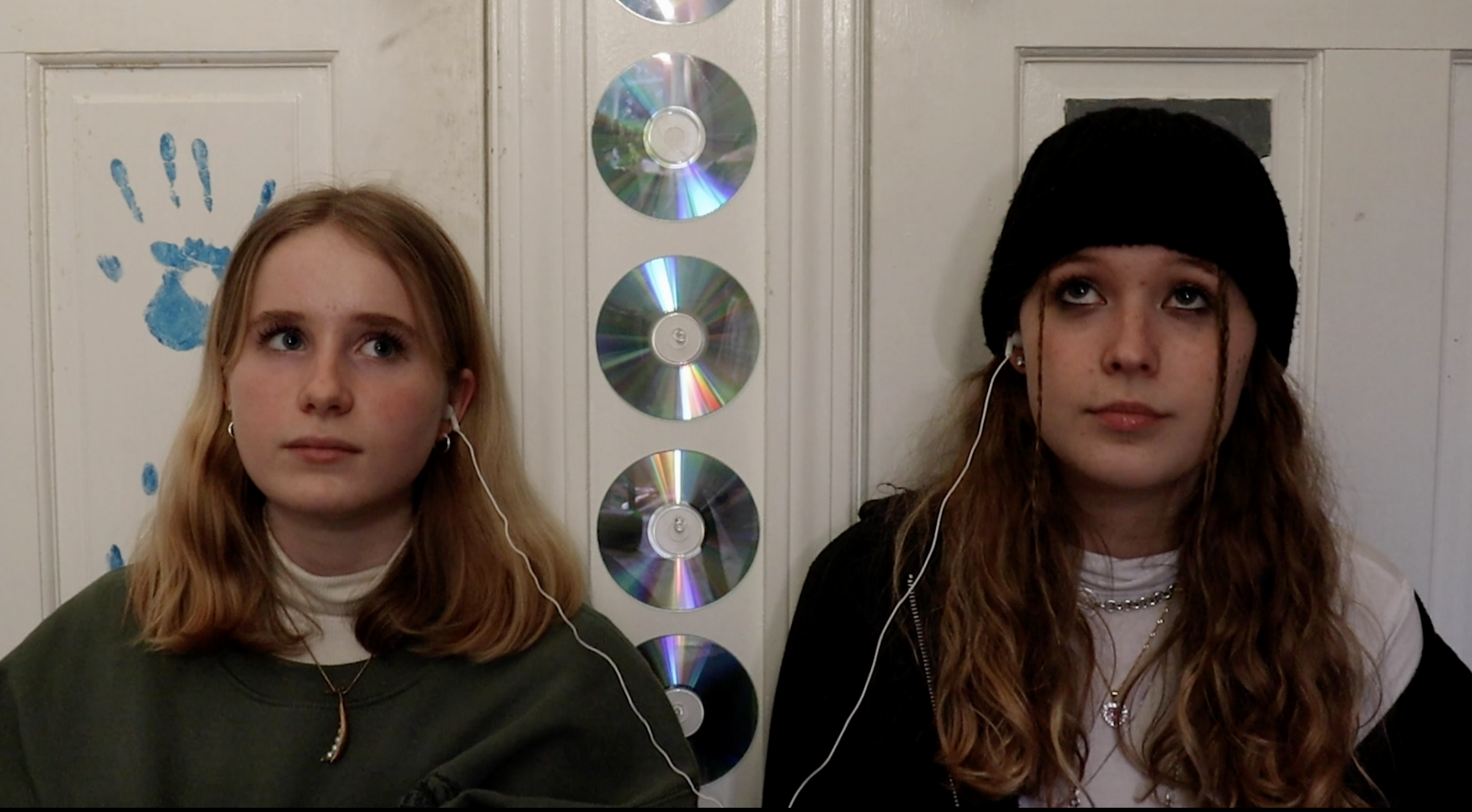 Still from Melting Ice of two teenage girls listening to music side by side