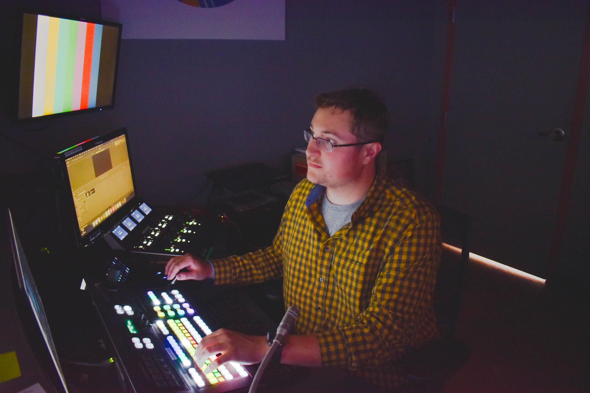 Logan sits at the control room table
