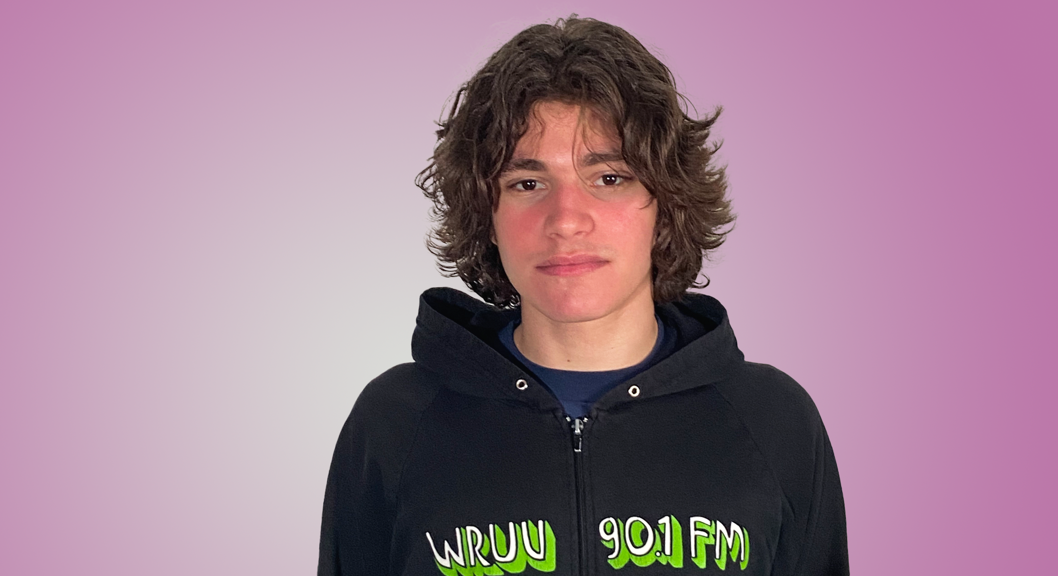 a medium shot of Nico Listi, wearing a black hoodie with WRUV printed on it
